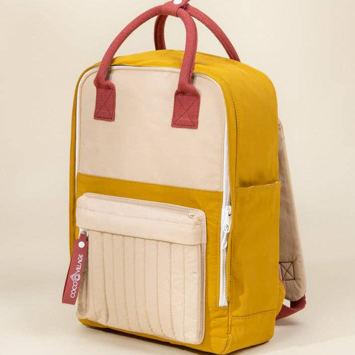 Yellow and beige backpack with red handles on a beige background