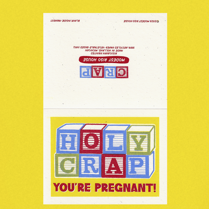 A folded greeting card or poster with a bright yellow border and a cream center panel. The lower section shows colorful toy-block-style letters spelling 'HOLY CRAP' with the phrase 'YOU'RE PREGNANT!' underneath.