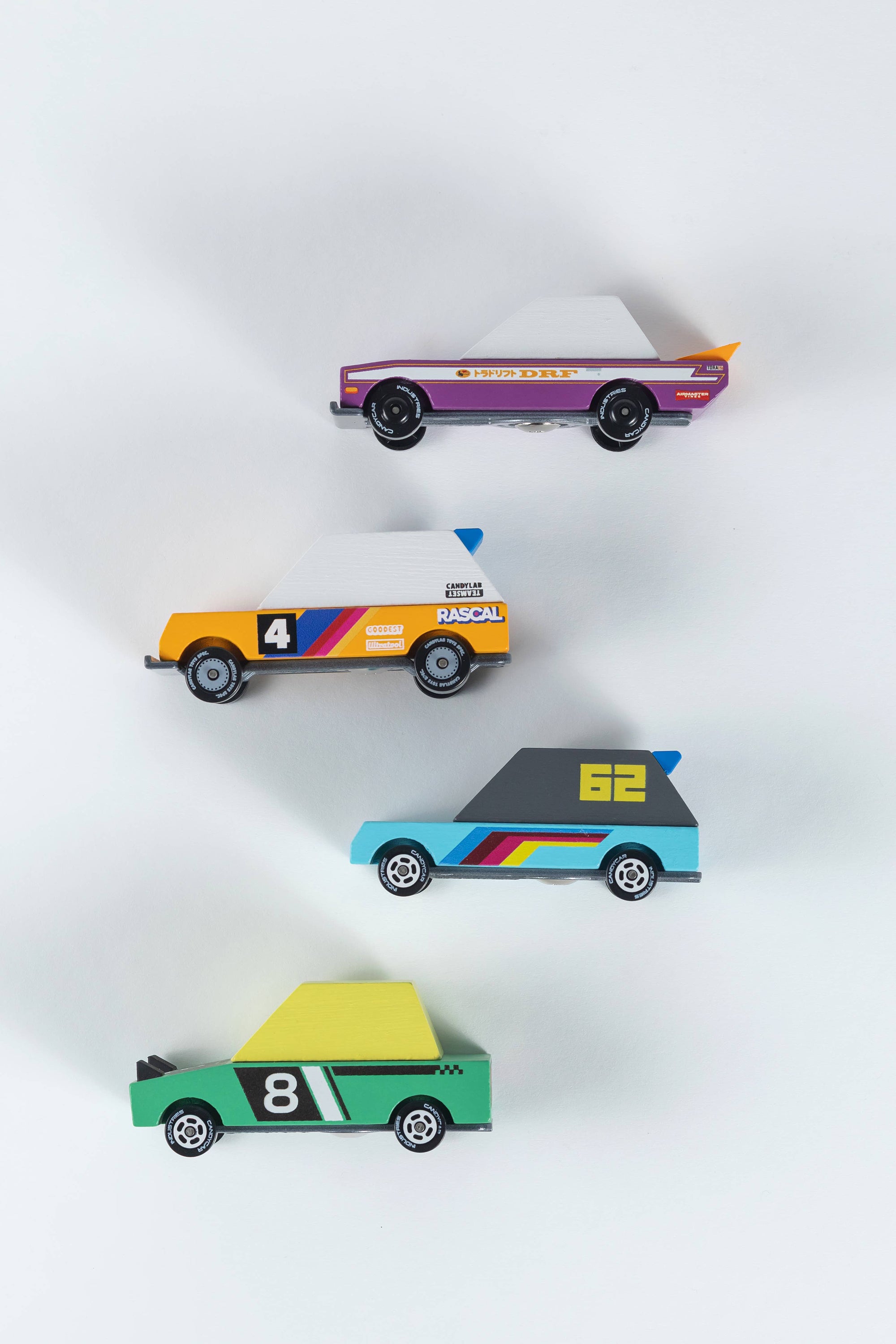 Four colorful toy cars arranged in a diamond pattern on a white background