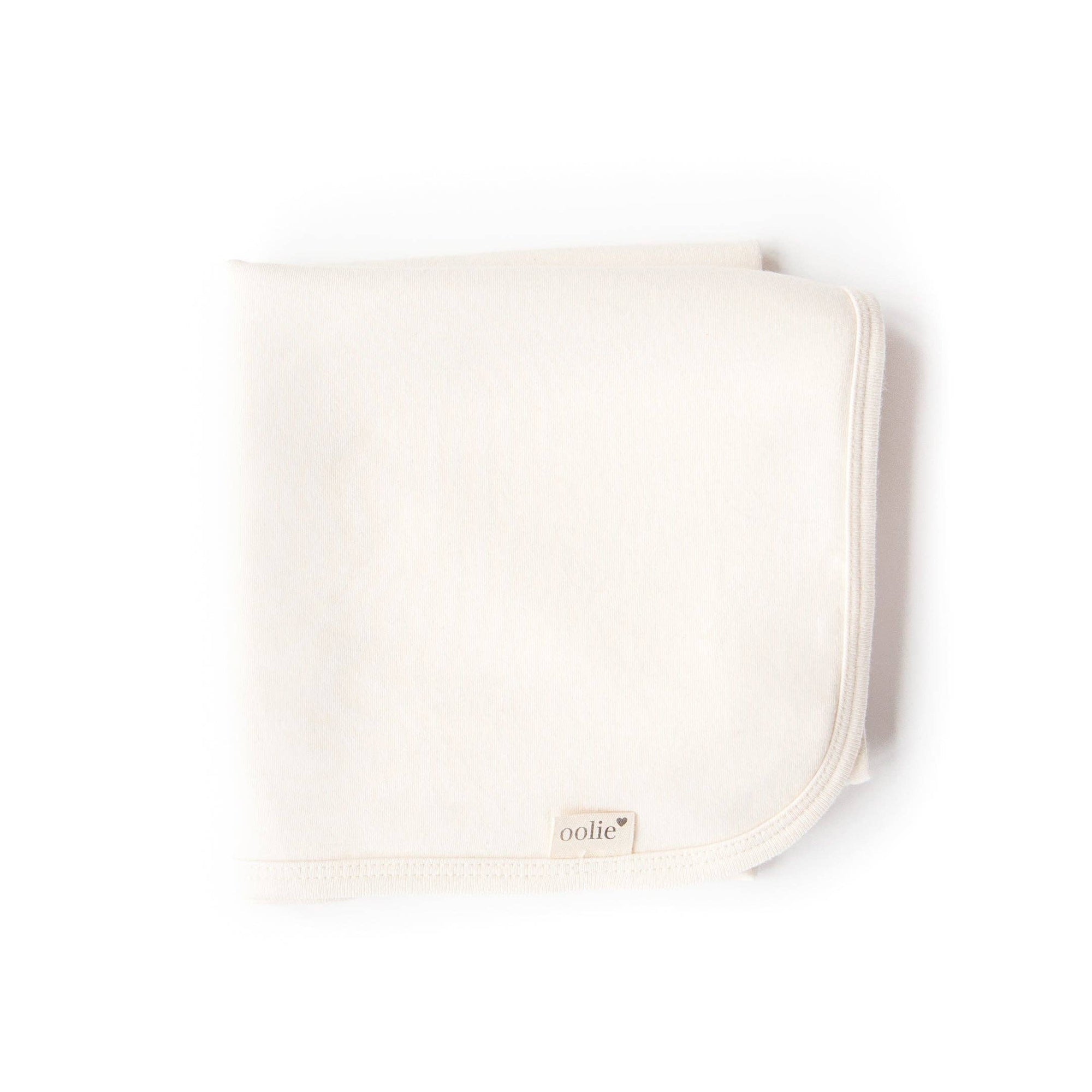 Beige baby blanket with 'oolie' branding on a white background