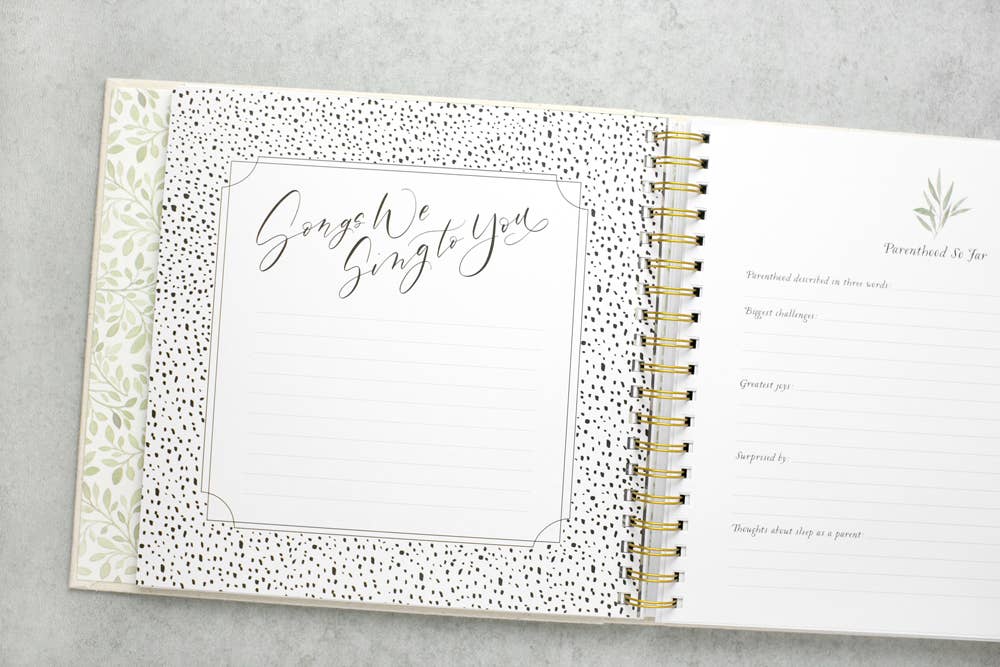 Open spiral-bound planner with decorative cover on a gray surface