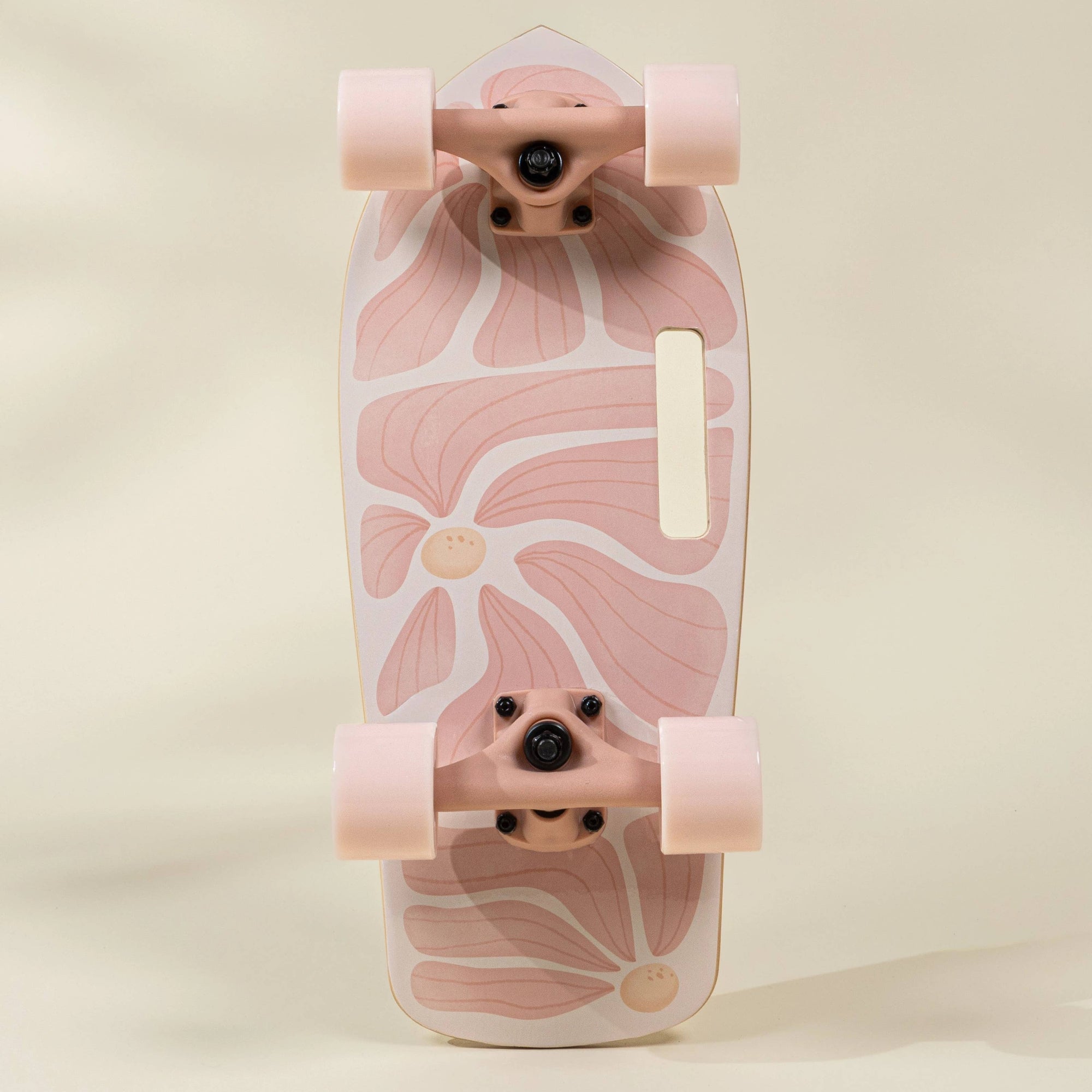 Pink floral-patterned skateboard on a beige background