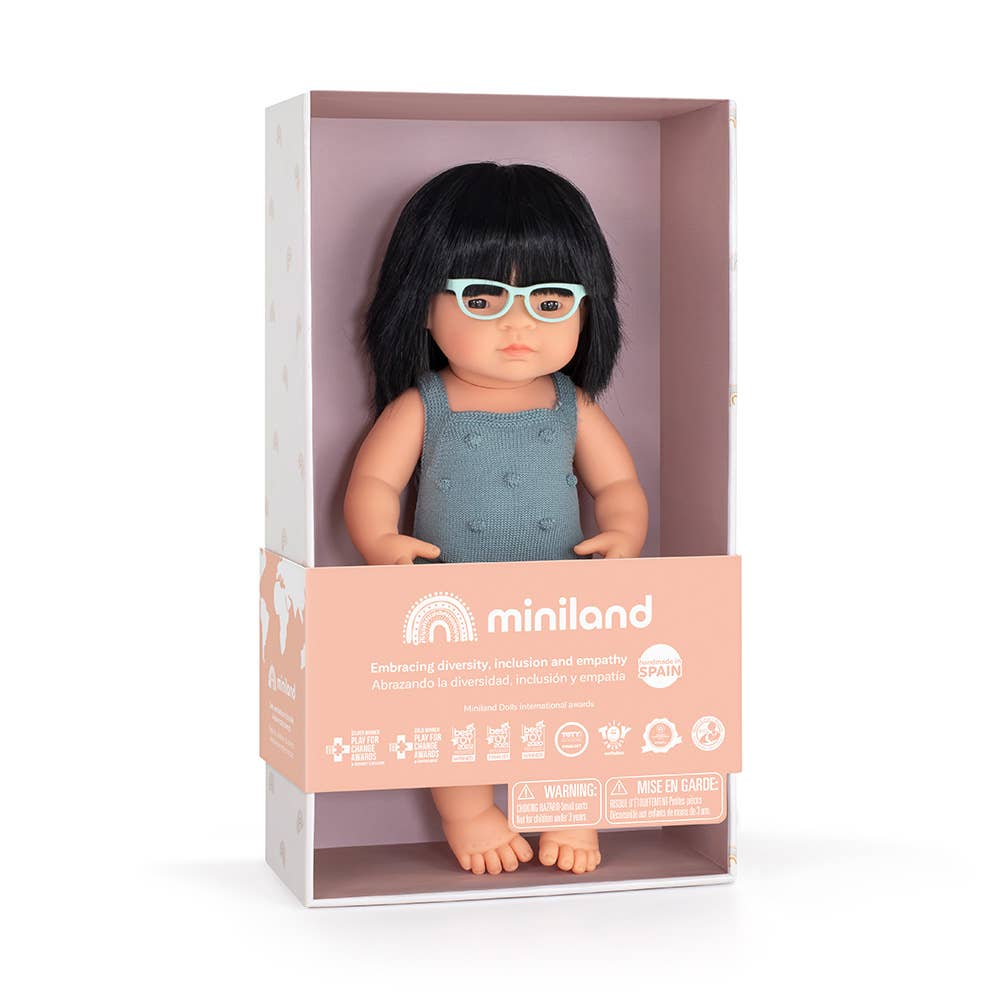 Doll with glasses in a Miniland packaging box on a white background