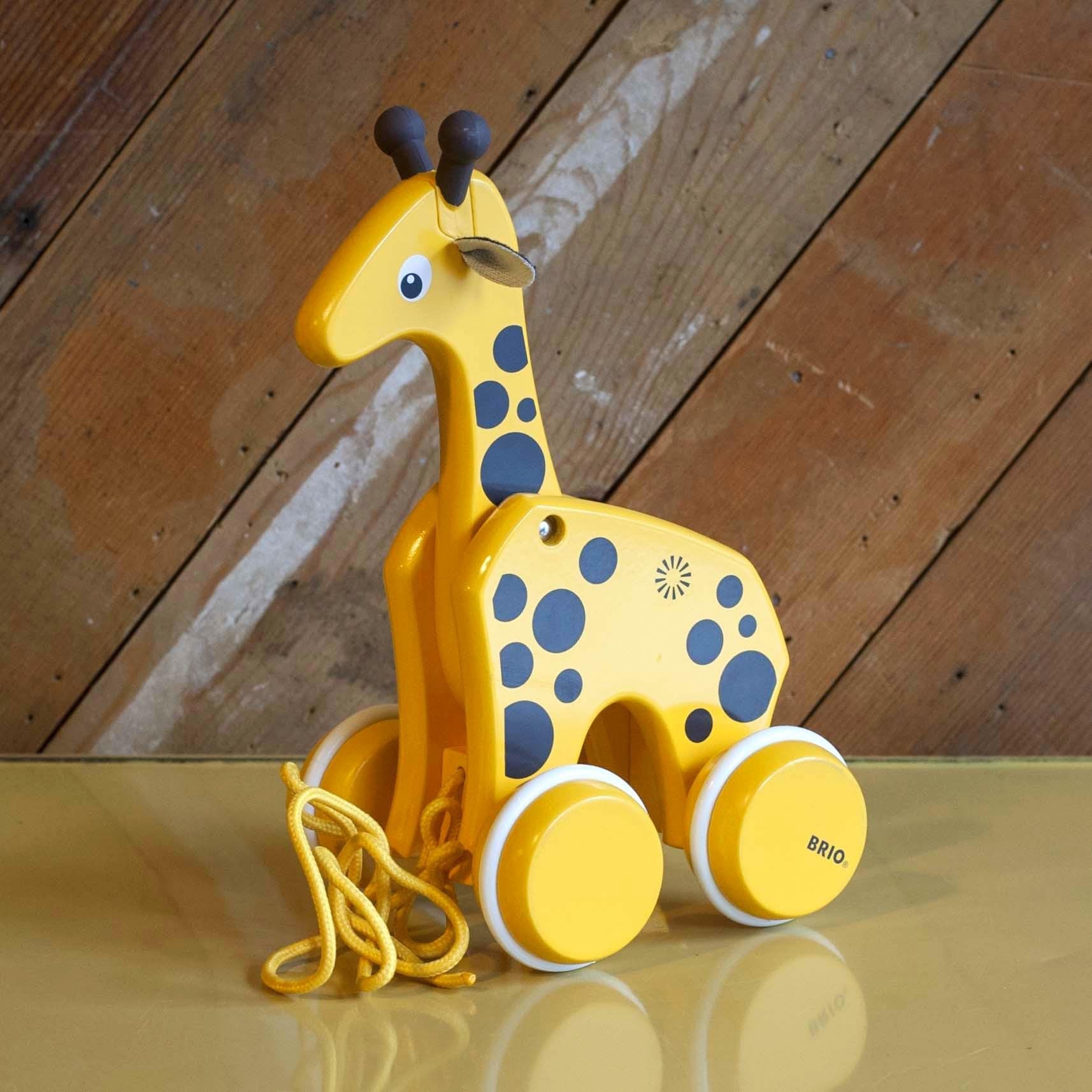 wooden, yellow giraffe pull toy on wooden back ground