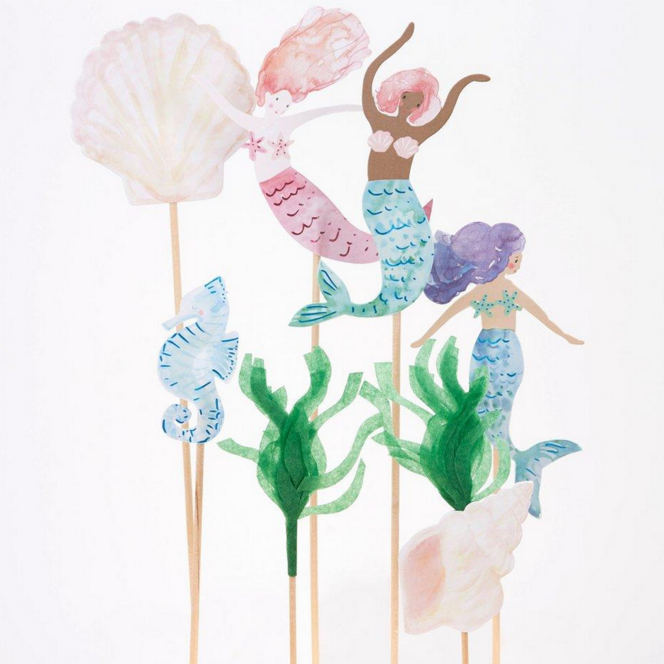 close up of 3 mermaids (with different skin tones) , two shells, a seahorse and tissue grass on long wooden sticks