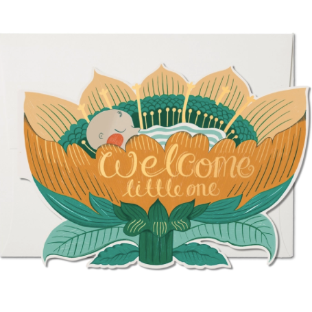 die cut orange flower with sleeping baby inside and words "welcome little one" written in gold