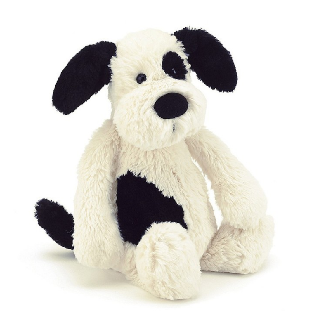 A plush toy depicting a black and cream puppy with a patch on its back and a sooty tail.