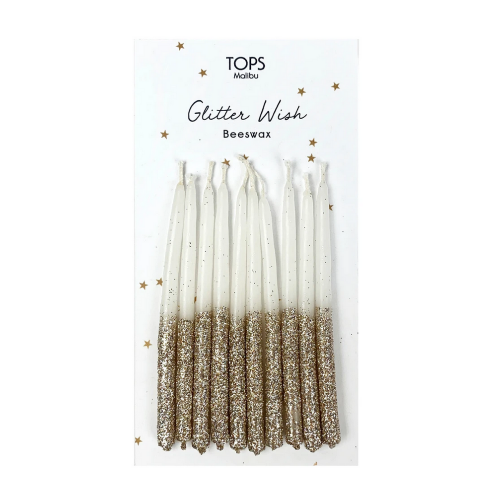 white candles with gold glittered bottoms within packaging