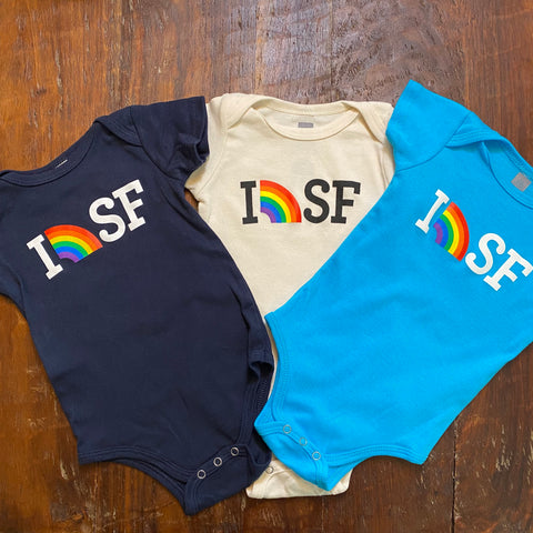 picture of dark blue, cream and aqua blue onsies with I (picture of rainbow) SF written on them