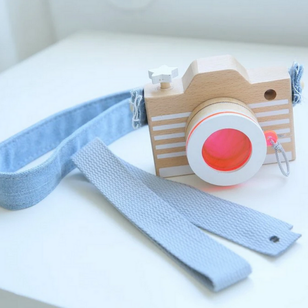 wooden camera with orange lens and denim strap