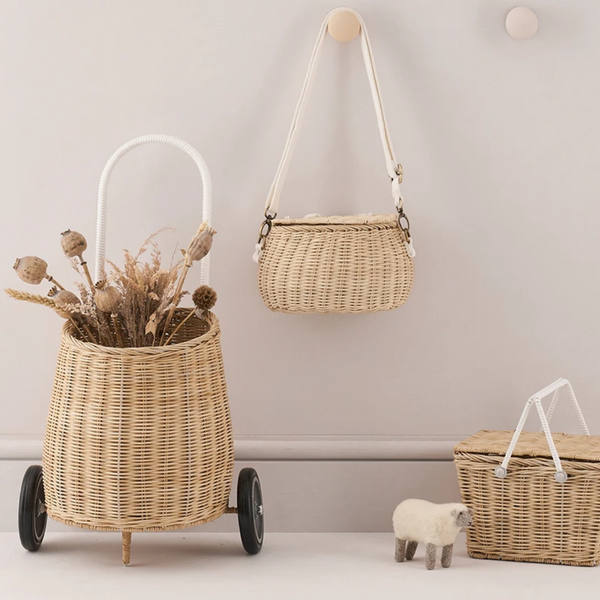 picture of basket next to a hanging purse and picnic basket