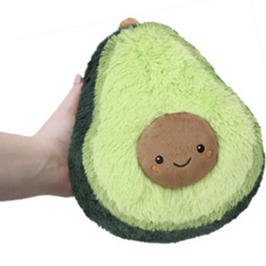 hand holding the small avocado plush with face on pit
