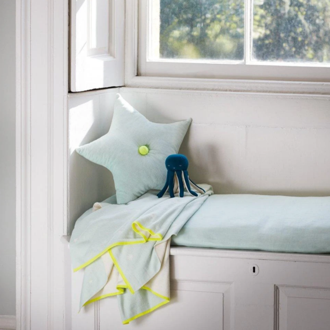 navy blue cloth octopus in window seat with star pillow