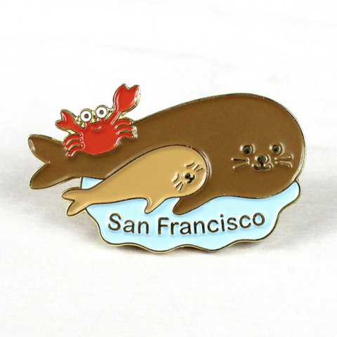 brooch with large and small seal and red crab with words saying San Francisco