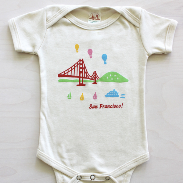 onesie with San Francisco's golden Gate Bridge, hot air balloons and sailboats on white background