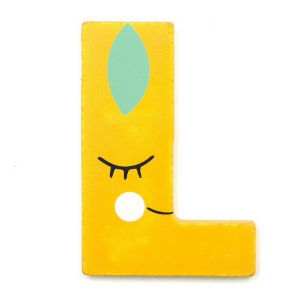This is the letter L. It is thin wood and yellow and looks like a lemon with a little face and leaf. by Suzy Ultman