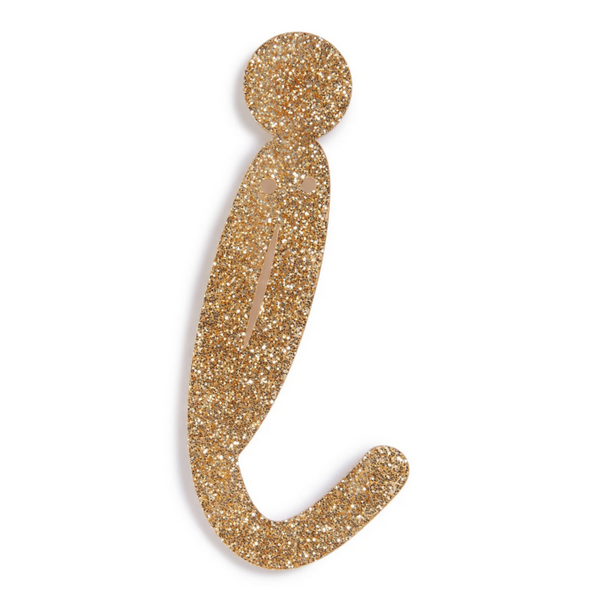 lowercase cursive i in gold acrylic with small holes to hang it.