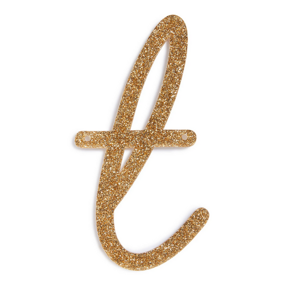 lowercase cursive t in gold acrylic with small holes to hang it.