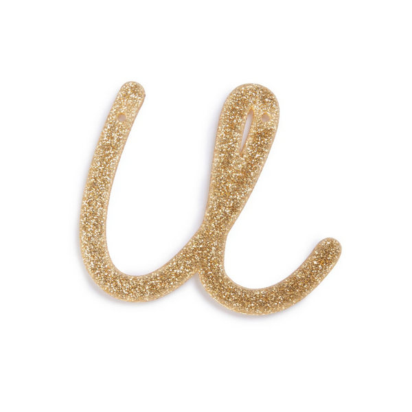lowercase cursive u in gold acrylic with small holes to hang it.