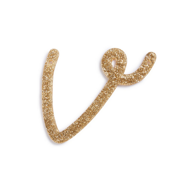 lowercase cursive v in gold acrylic with small holes to hang it.