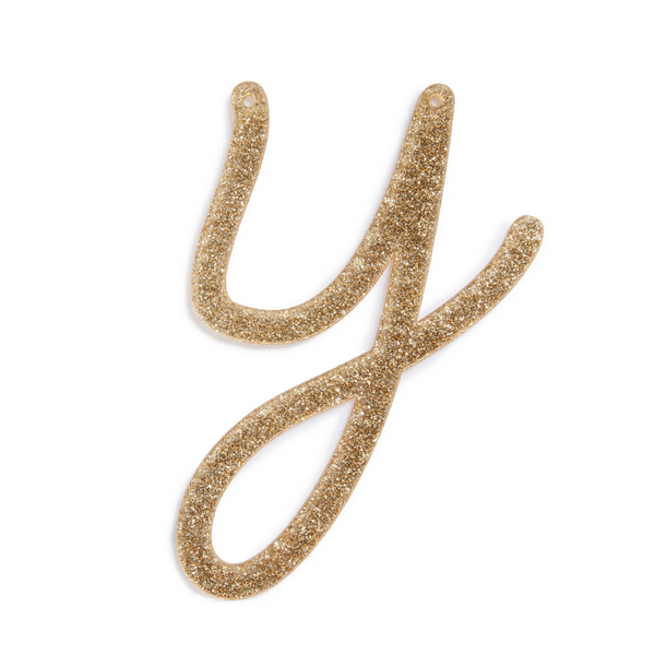 lowercase cursive y in gold acrylic with small holes to hang it.