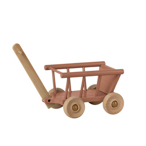 wooden wagon with rose colored main part and brown wheels and handle