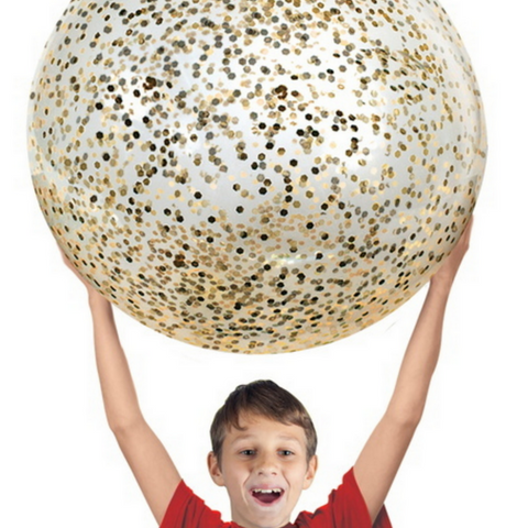 boy holding giant gold glittered ball above head