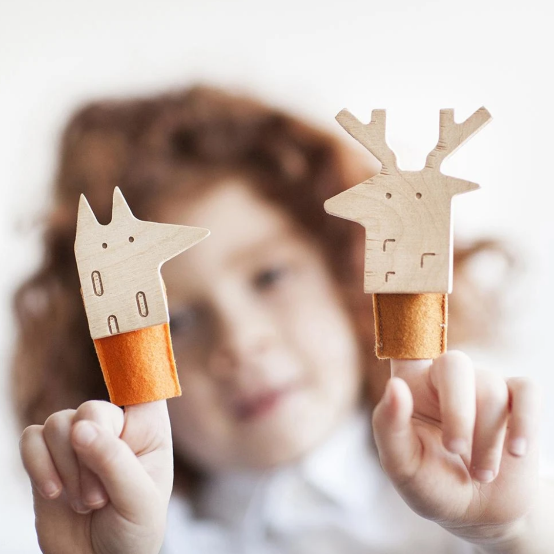 child with two finger puppets on fingers