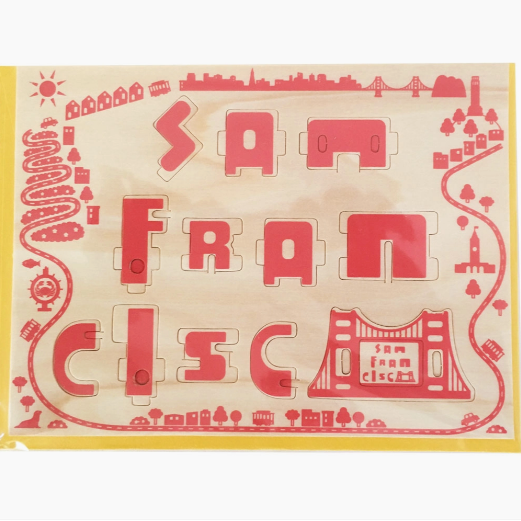 san francisco wood puzzle card before it transforms into wooden figure of Golden gate Bridge holding San Francisco sign with a yellow face