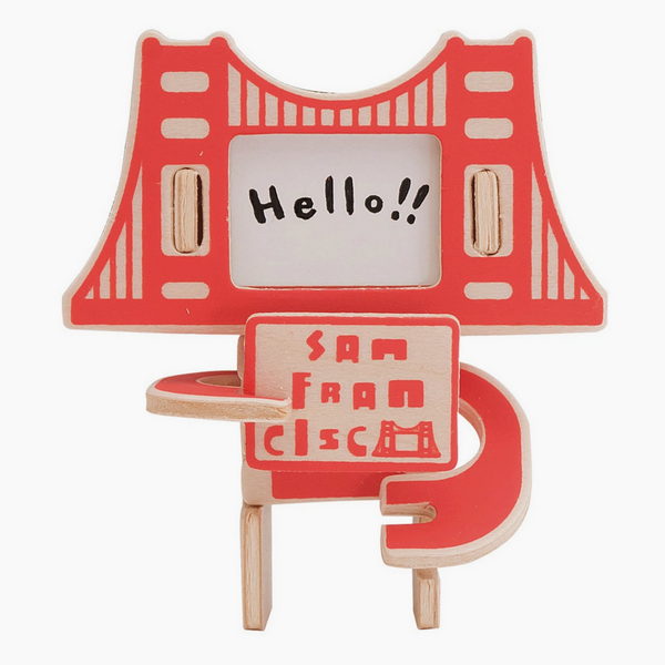 wooden figure of Golden gate Bridge holding San Francisco sign with a signed face