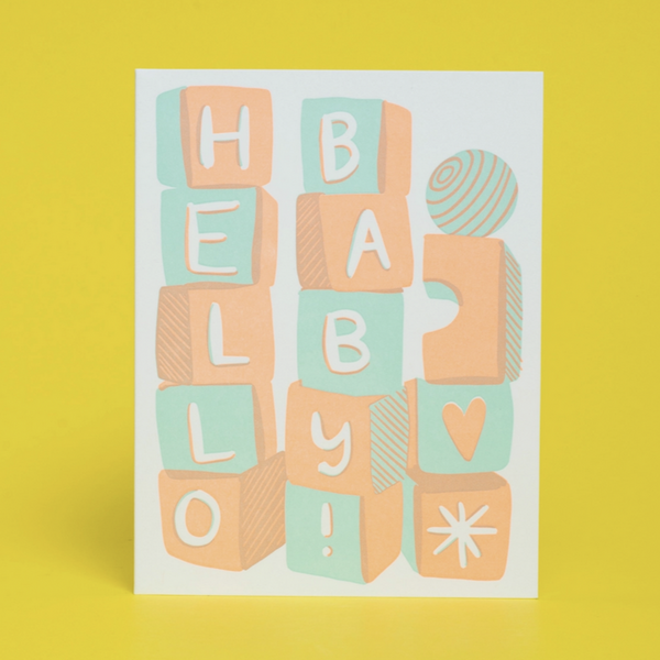 card with pink and blue blocks reading "hello baby!" on yellow background