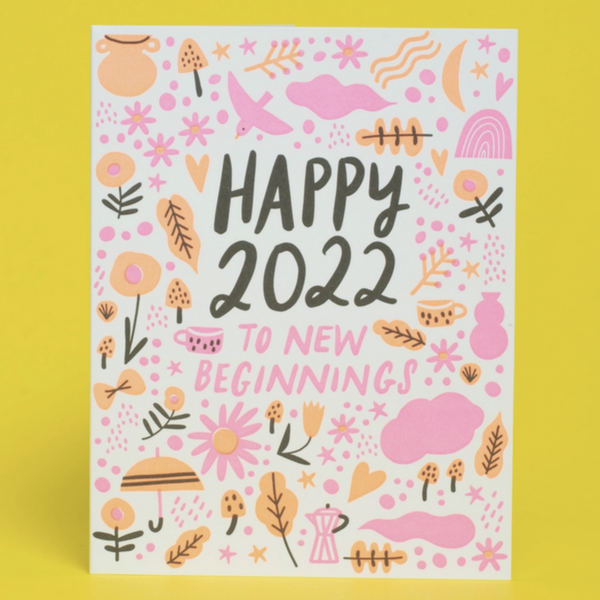 card with pink and peach flowers, unbrells, bird, rainbow icons reading "happy 2022 to new beginnings" on yellow background