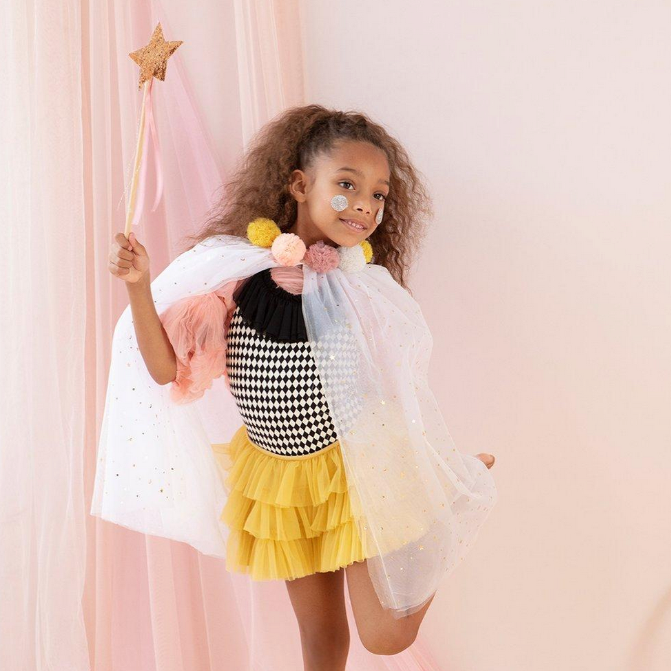 little girl posing with cape holding wand