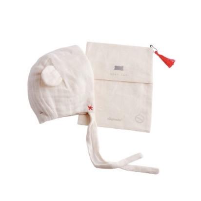 cream bonnet with bear ears shown outside of cloth pocket that it comes in