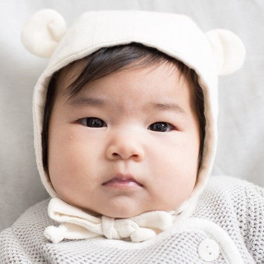 baby wearing cream bonnet with bear ears