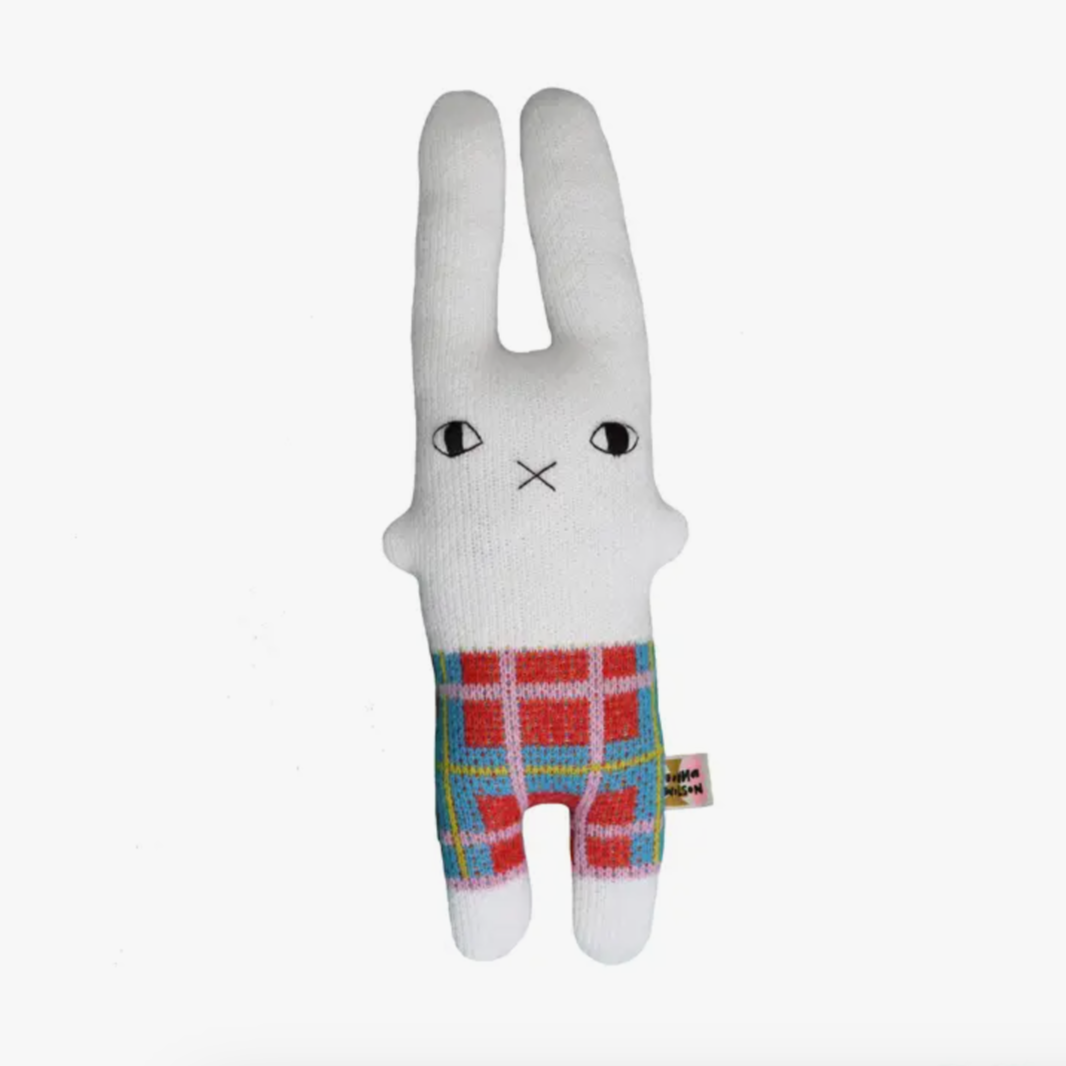 A plush toy in the shape of a rabbit featuring a plaid pattern on its legs, primarily in white and red/green colors, with a predominantly white body.