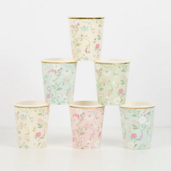 A set of four cups with floral patterns in pink, mint, light blue, and cream colors, featuring gold foil details.