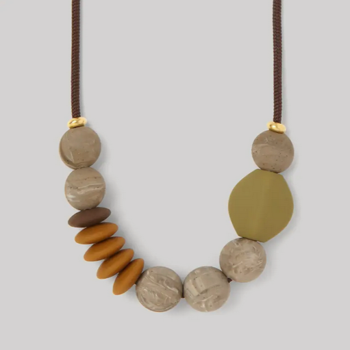 A beaded teething necklace with a variety of shapes and colors, including round and oval beads in shades of brown, white, and green, finished with a safety-tested clip.