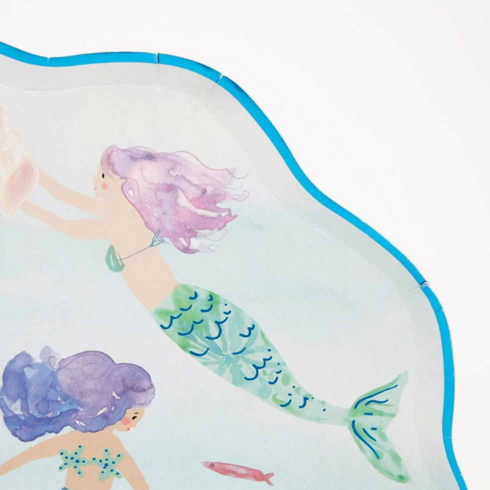 detail of mermaids simming on blue plate with blue foiled and scalloped edge