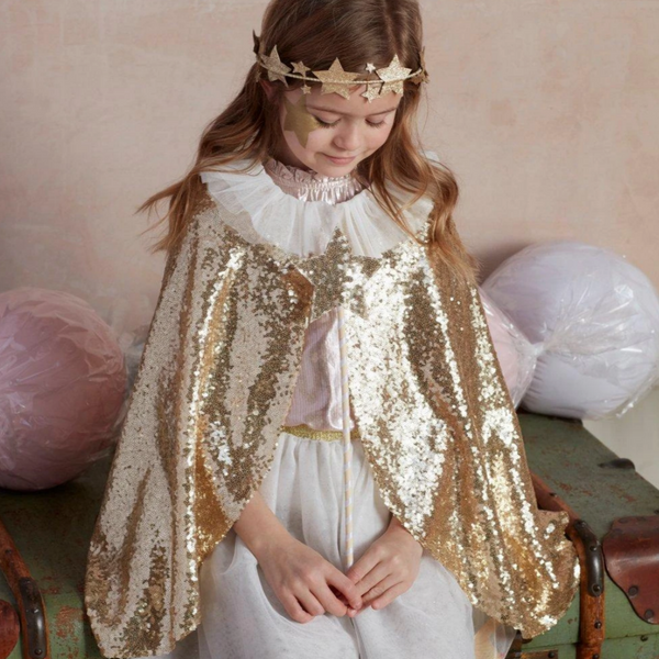 little girl wearing sparkly gold cape with white tulle collar holding golden star wand