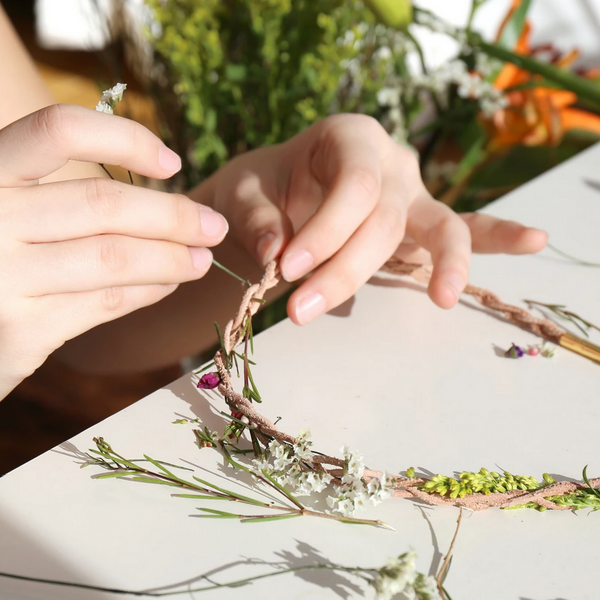 hands adding flowers to necklace