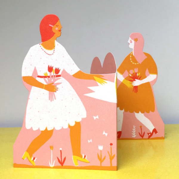 two women walking towards eachother when card slightly opened