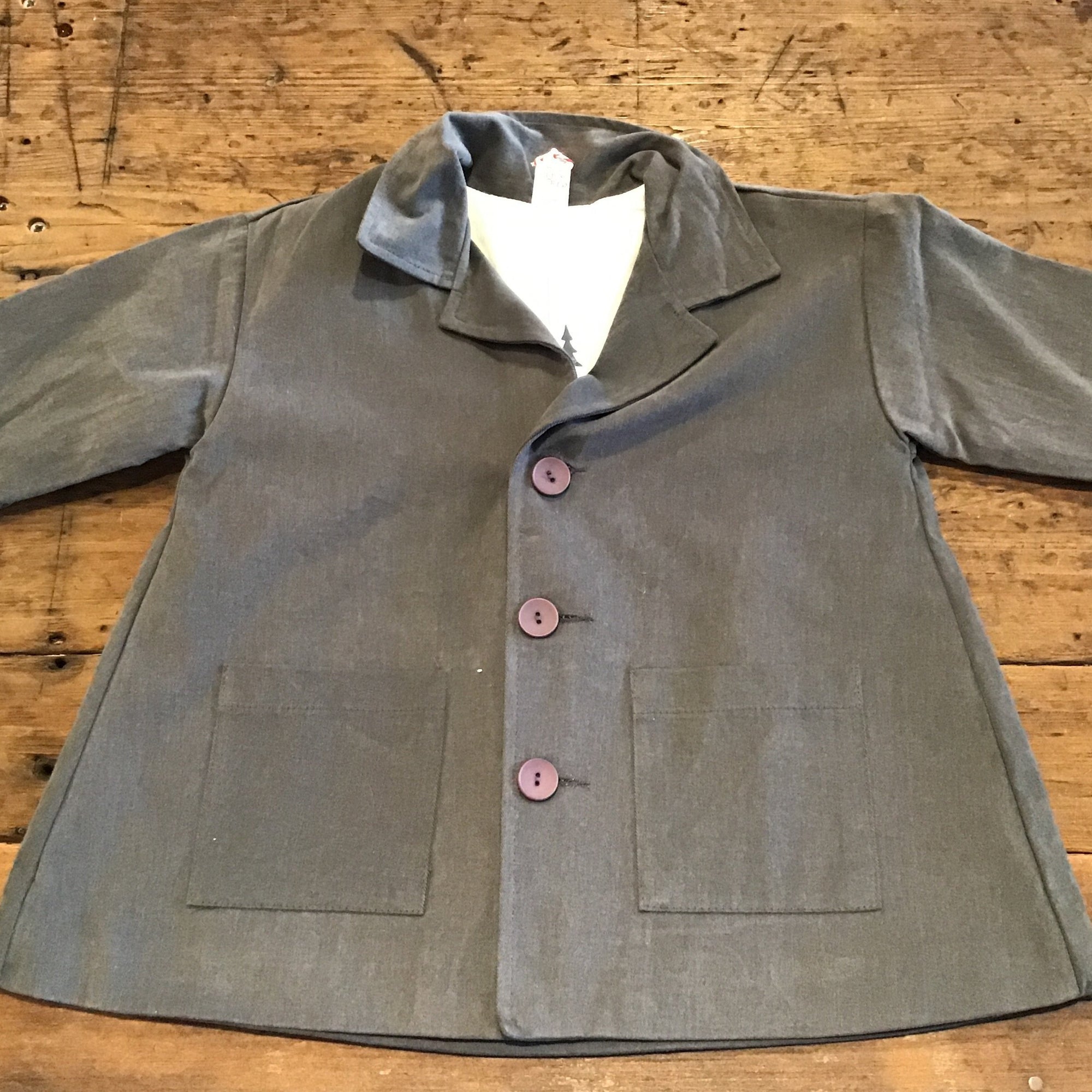 grey jacket with pockets and pinkish buttons