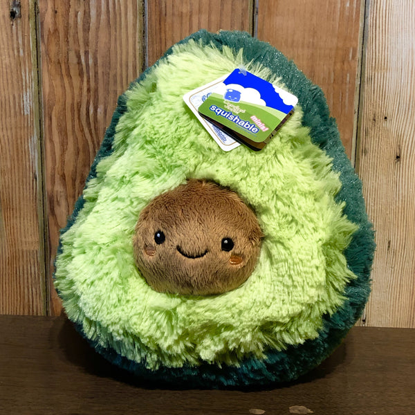 fluffy avocado plush with face on pit