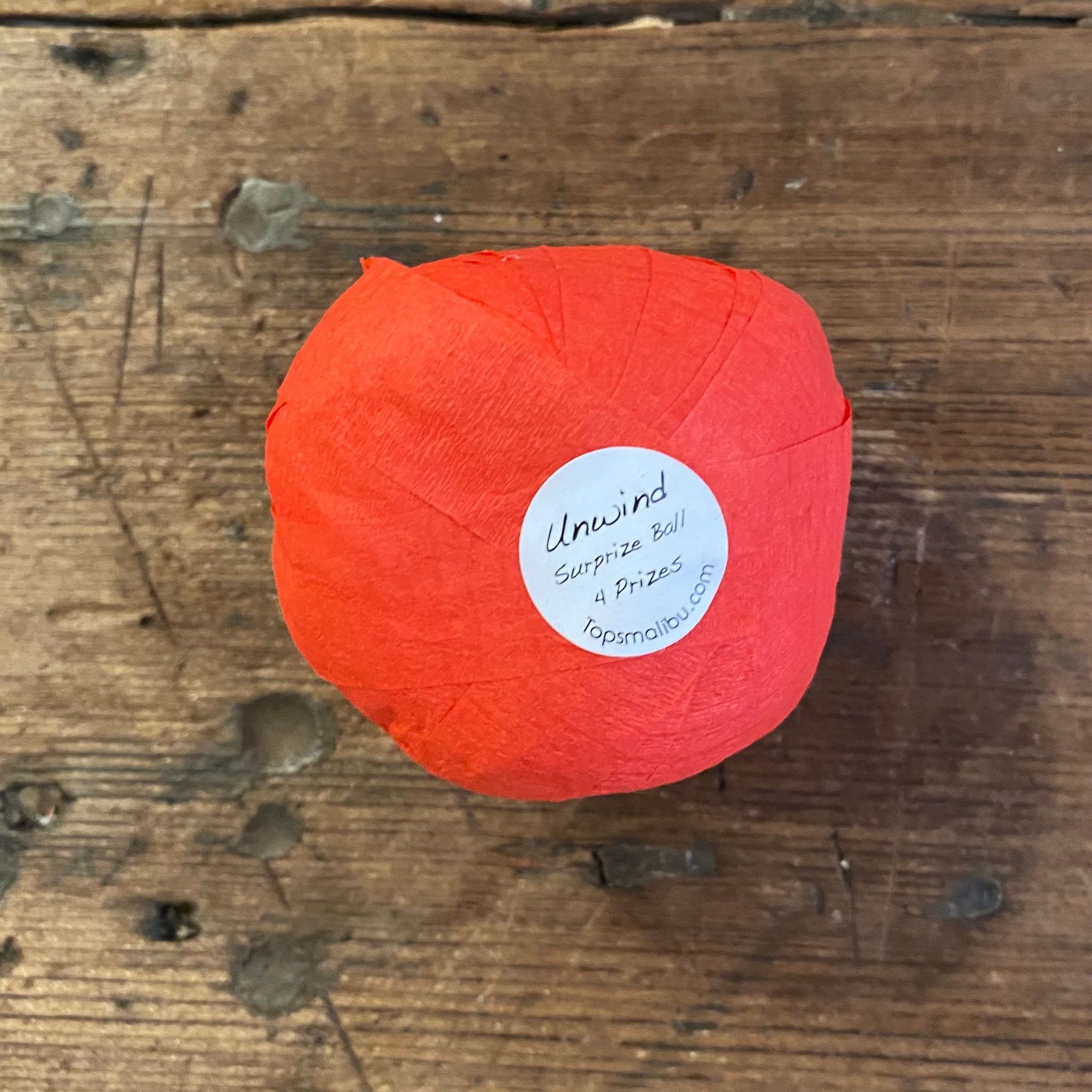 sticker on bottom of red surprize balls that say "unwind! Surprize ball 4 fun prizes
