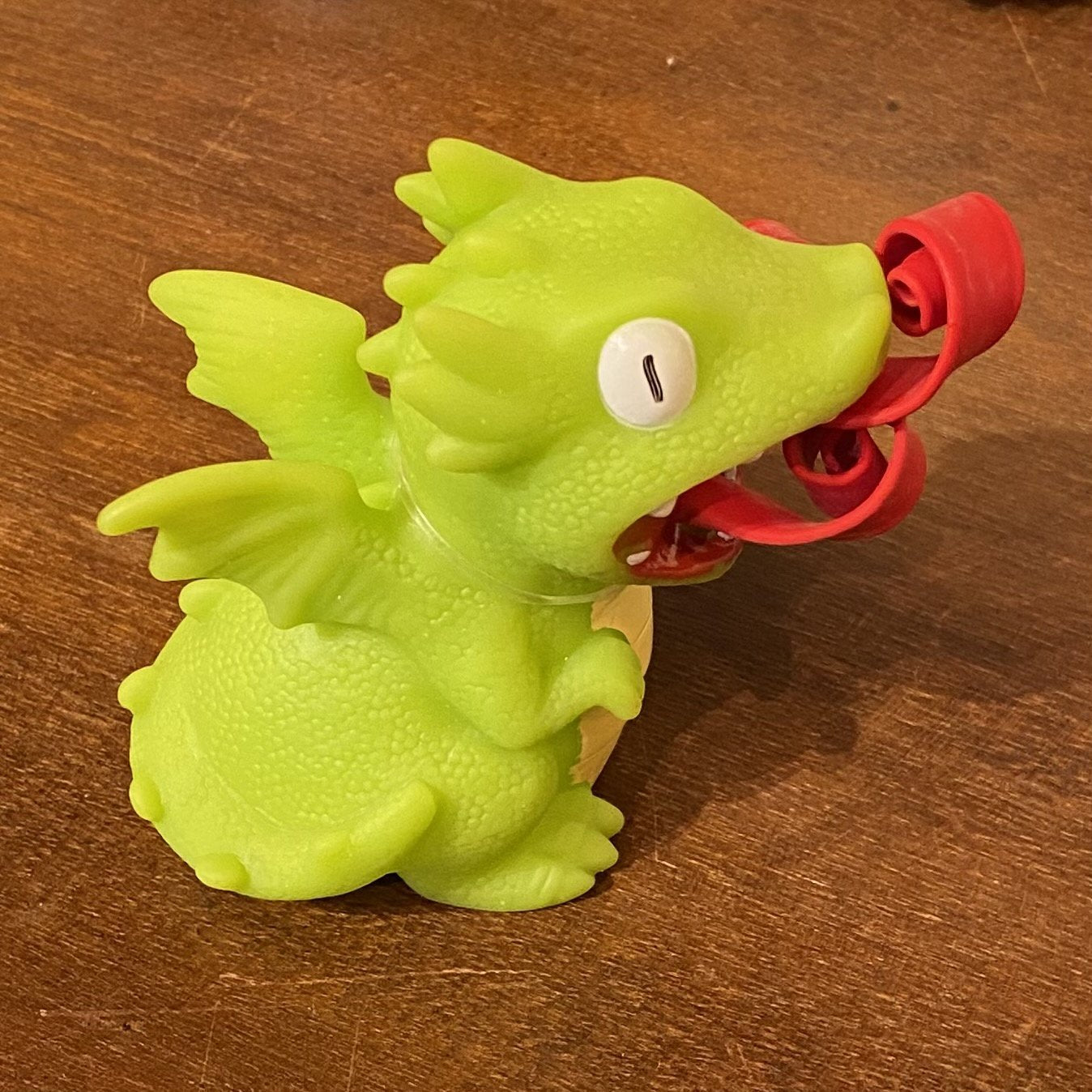 green orange, blue and green dragon with curled up fire in mouth