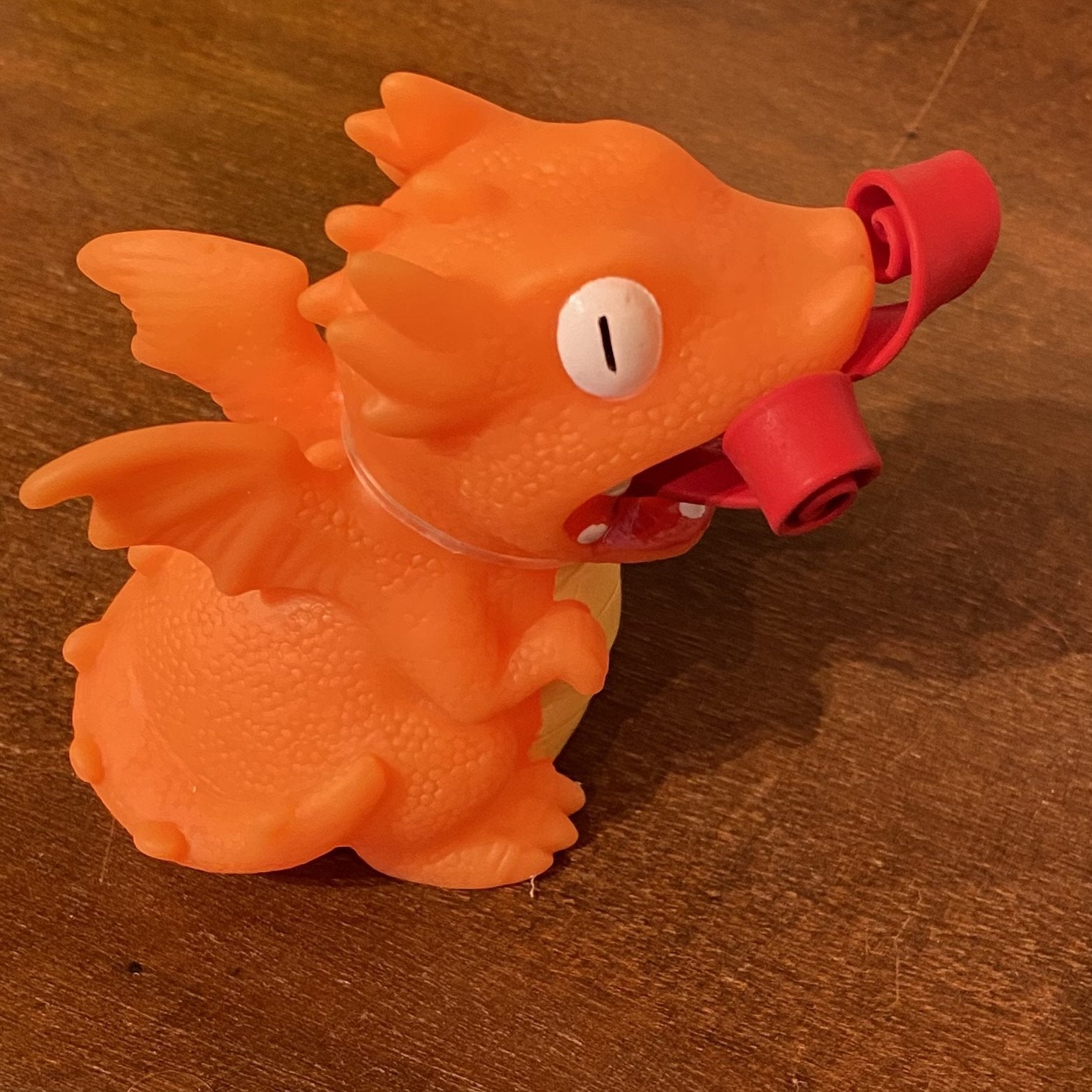 orange dragon with curled up fire in mouth